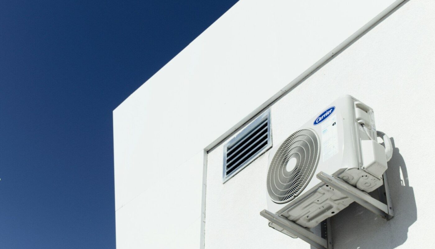 un climatiseur blanc fixé sur le côté d'un bâtiment