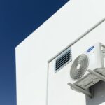 un climatiseur blanc fixé sur le côté d'un bâtiment