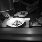 Assiette blanche avec plat de cuisine, bol, ustensiles sur une table de cuisine