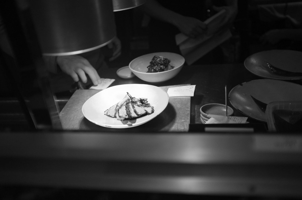 Assiette blanche avec plat de cuisine, bol, ustensiles sur une table de cuisine