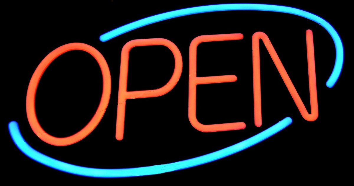 Lumière néon orange formant le mot OPEN, encadré par deux ovales bleus