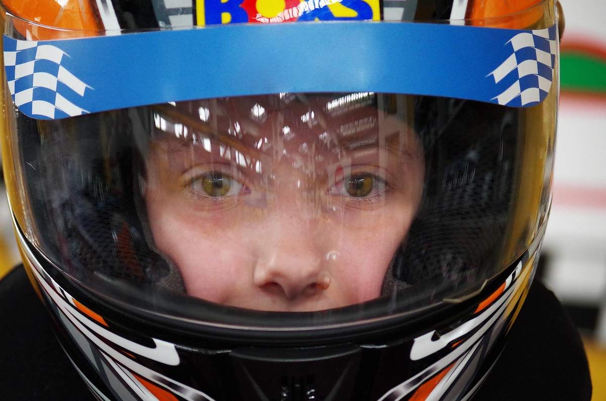 Visage d'une personne derrière le visor d'un casque de course Visage d'une personne derrière le visor d'un casque de course