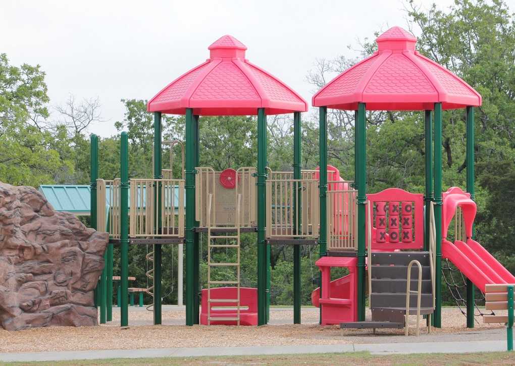 Structure de jeu extérieure avec deux toits rouges et un toboggan Structure de jeu extérieure avec deux toits rouges et un toboggan