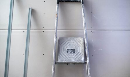 Un escalier et un marche‑pied posés contre un mur de plaques sèches